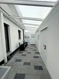 Überdachter Zugang zu Garage und Haus