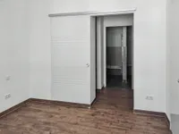 Schlafzimmer mit Glasschiebetür in Ankleide und Bad