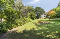 Blick über das parkähnliche Grundstück zum erhöhten Wohnhaus