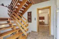Zentraler Eingangsbereich mit charaktervoller Holztreppe