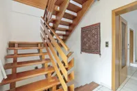 Offene Holztreppe als Verbindung der Wohnebene im EG und dem Schlafbereich im OG