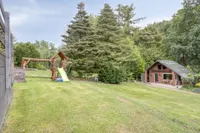 Familienfreundliche Gartenfläche mit Spielgeräten und charmantem Gartenhaus 