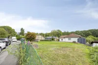 Straßenansicht mit potenzieller Baufläche und Blick auf das Haupthaus