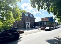 Hauptgebäude im Vordergrund, dahinter Hallenanbau