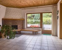 Wohnzimmer mit Kamin und Gartenausgang