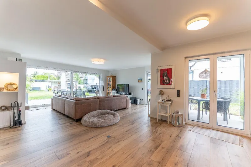 Wohnbereich mit Kamin und mehreren Zugängen zum liebevoll angelegten Garten