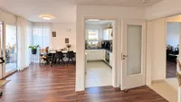 Wohn-/Esszimmer mit Küche und Zugang zum Balkon