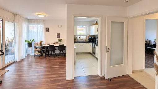 Wohn-/Esszimmer mit Küche und Zugang zum Balkon