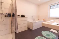 Badezimmer mit Badewanne, Dusche und modernem Design.