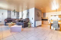 Stilvoll eingerichtetes Wohnzimmer mit großer Polsterecke, dekorativen Wandobjekten und Blick zur Wohnwand.