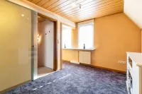 Helles Kinderzimmer mit Teppichboden, zwei Fenstern und modernem Glasschiebetür-Zugang.