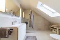 Das Schlafzimmerbad: Klar strukturiert, stilvoll modernisiert und mit großzügiger Dusche – ideal für den täglichen Komfort.