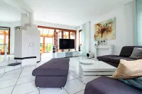 Ein großzügiges Raumgefühl, große Fensterflächen und direkter Zugang zum Wintergarten machen dieses Wohnzimmer zum Herzstück des Hauses.