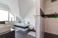 Elegantes Badezimmer mit klaren Linien, großformatigen Fliesen und stimmiger Lichtgestaltung.