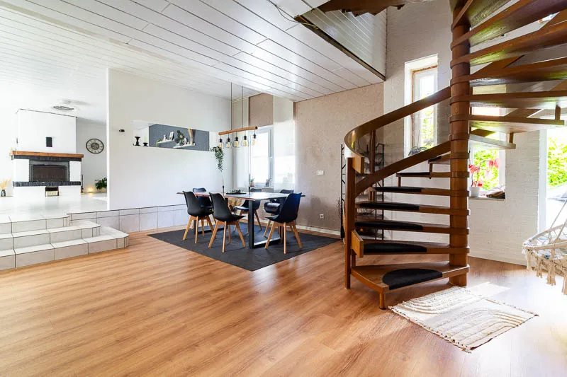 Offene Grundrissgestaltung mit Blick zur Küche und eleganter Holztreppe – ein echtes Wohnhighlight.