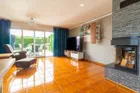 Wohnzimmer mit bodentiefen Fenstern, Blick in den Garten und Zugang zur überdachten Terrasse – ein Wohnbereich mit Weitblick.