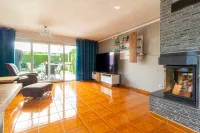 Wohnzimmer mit bodentiefen Fenstern, Blick in den Garten und Zugang zur überdachten Terrasse – ein Wohnbereich mit Weitblick.