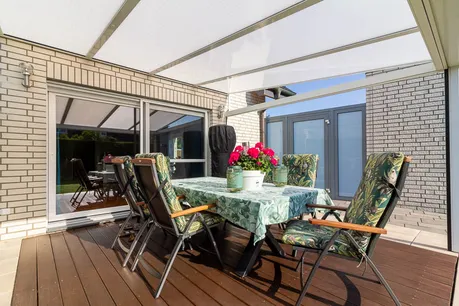 Die Terrasse, überdacht und mit direktem Zugang zum Garten – der perfekte Ort für entspannte Stunden im Freien.