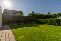 Pflegeleichter Garten mit blickdichtem Heckenzaun und liebevoll angelegten Beeten – perfekte Privatsphäre für erholsame Stunden im Grünen.