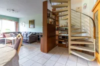 Elegante Wendeltreppe, die das offene Raumkonzept perfekt ergänzt und den Zugang zum Obergeschoss ermöglicht.