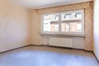 Helles Schlafzimmer mit großem Fenster – viel Potenzial für einen gemütlichen Rückzugsort.