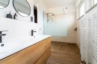 Modern, hell und komplett kernsaniert – das Badezimmer überzeugt mit begehbarer Dusche, Doppelwaschbecken und hochwertiger Ausstattung.