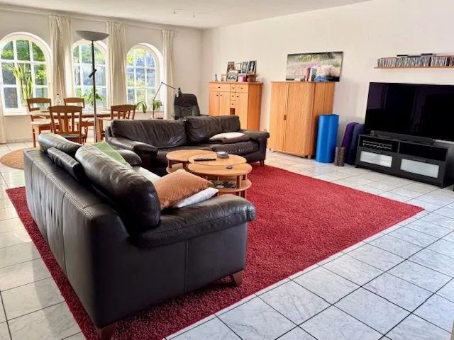 Das großzügige Wohnzimmer mit der Fensterfront zum Garten