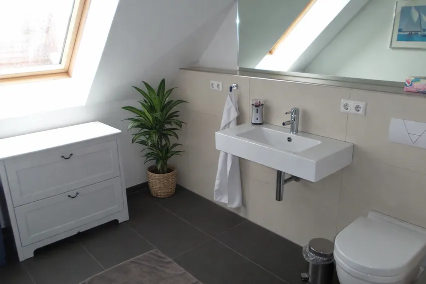 In allen Räumen, wie auch hier im modernen Badezimmer, ist Fußbodenheizung verlegt