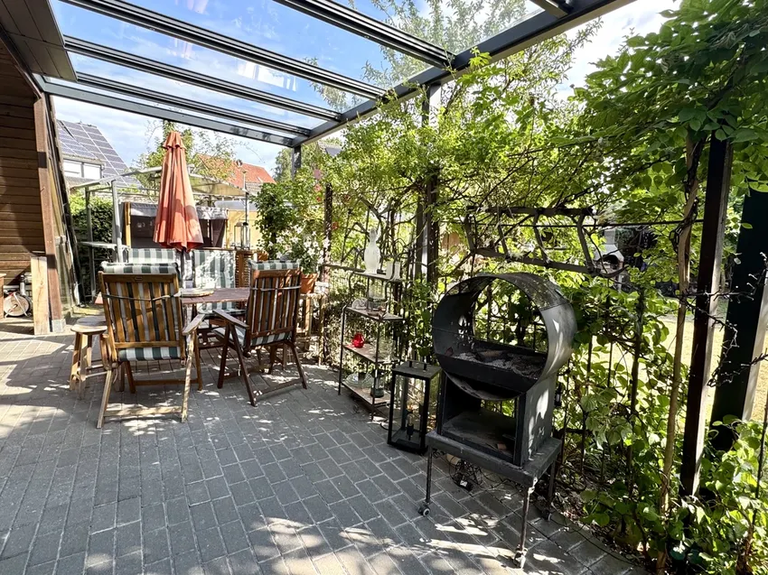 Überdachte Terrasse mit grünem Sichtschutz