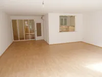 Wohnzimmer mit offener Einbauküche
