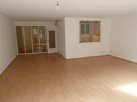 Wohnzimmer mit offener Einbauküche
