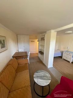 Wohnung im Souterrain einer Stadtvilla, Wohnraum mit Tisch u.Sesseln