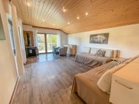 Wohnbereich mit Kamin und Zugang zum Balkon