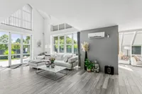 Open, light-filled living, dining, and kitchen area with a sunroom