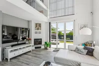 Open, light-filled living, dining, and kitchen area with a sunroom