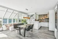 Open, light-filled living, dining, and kitchen area with a sunroom