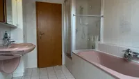 und Badewanne, dahinter eine Dusche