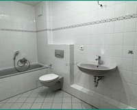 Modernes, wandhoch verfliestes Badezimmer mit Dusche und Badewanne