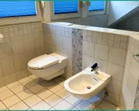 mit Bidet und einer hellen Verfliesung