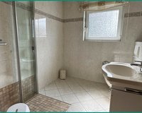 Badezimmer mit heller Verfliesung, Fenster und