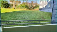 Blick vom Balkon in das grüne Gemeinschaftsgrundstück