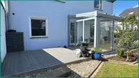 Große Terrasse aus Kunststoffbohlen mit Zugang zur Garae