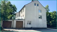 Gebäudeansicht mit Garagen links