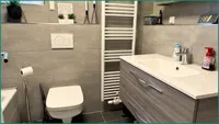 Modernisiertes Badezimmer mit Fenster und Handtuchheizkörper und...