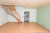 Wohnraum mit offener Treppe und Küchenzugang