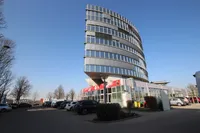 Blick auf das Gebaude von Westen mit Parkplatzen